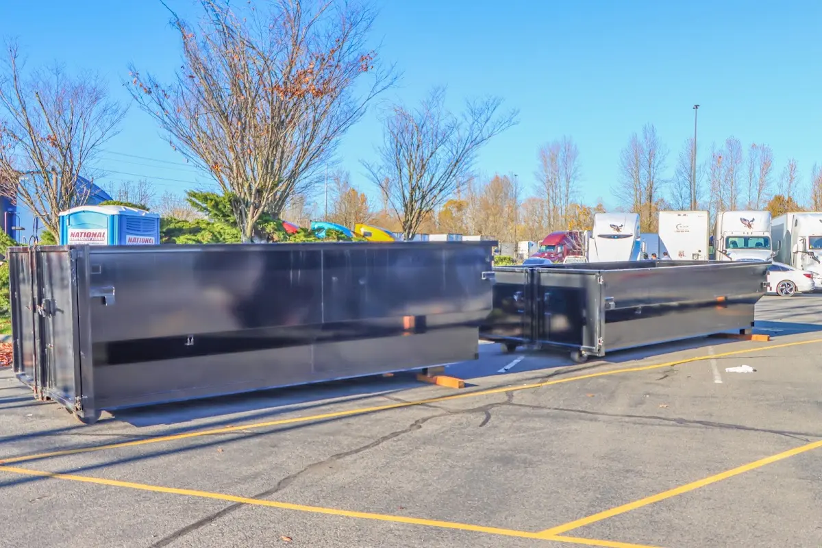 Professional dumpster rental service with roll-off container on residential driveway in Manorhaven